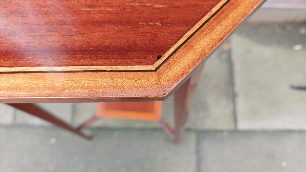 An Edwardian mahogany torchere stand featuring an octagonal top with satinwood inlay, four slender splayed legs, and a square lower undertier. View VI