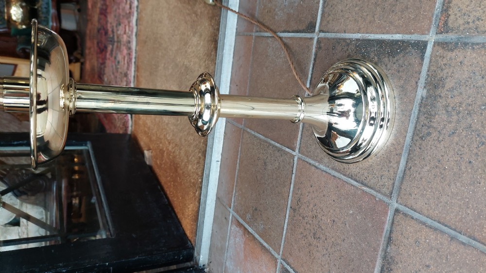 A pair of turned brass candlestands fitted with deep blue fringed dome shades decorated with a floral motif. View III
