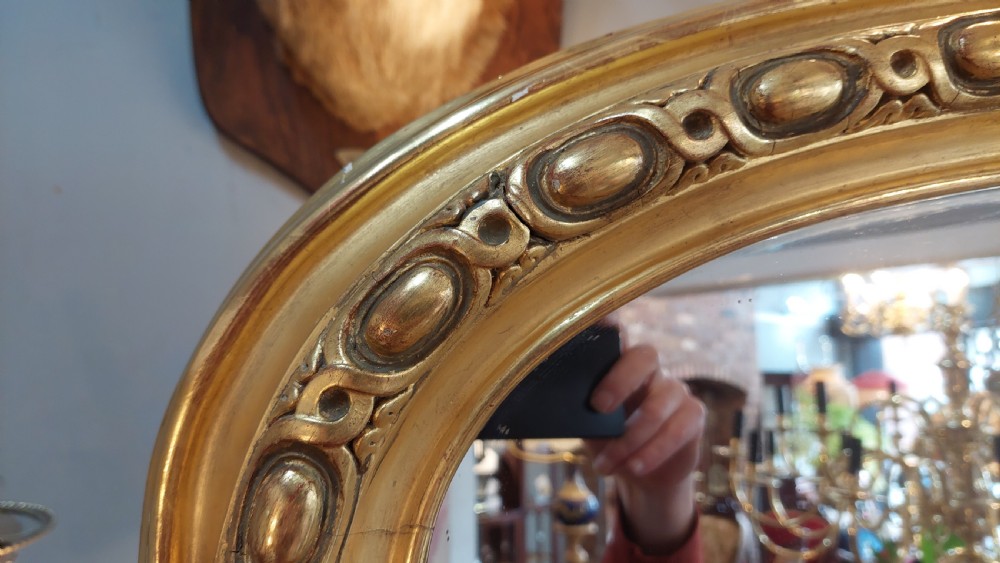 A large Victorian giltwood mirror featuring an arched upper frame, detailed bead moulding, and carved scroll feet at the base. View III