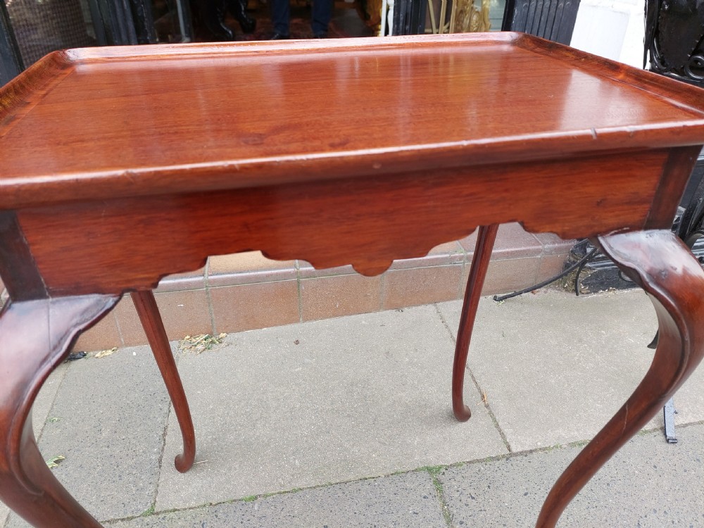 A 19th-century mahogany silver table featuring a raised tray top, shaped apron, and slender cabriole legs. View VII