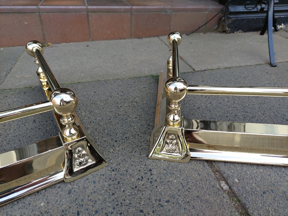 A pair of polished brass adjustable fireplace fenders featuring turned ball finials and telescopic rails. View II