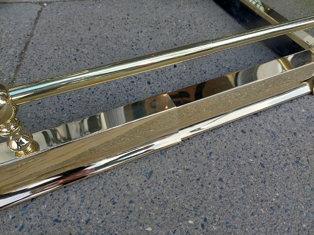 A pair of polished brass adjustable fireplace fenders featuring turned ball finials and telescopic rails. View IV