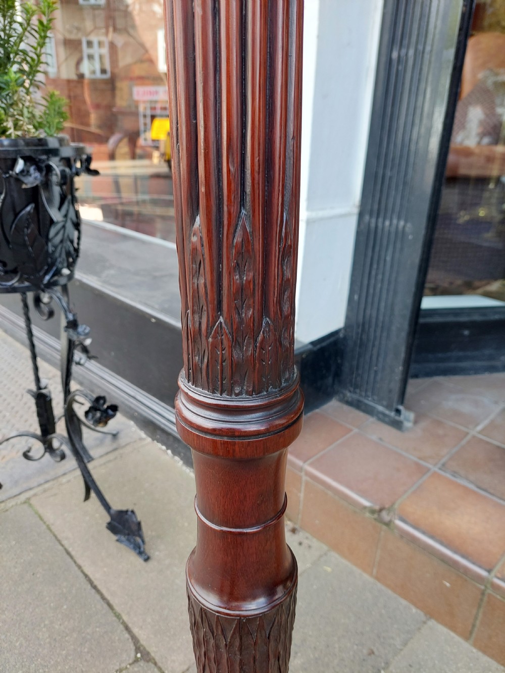 A tall mahogany Adam Revival torchere stand featuring a fluted column, carved tripod legs, and a circular top. View IV