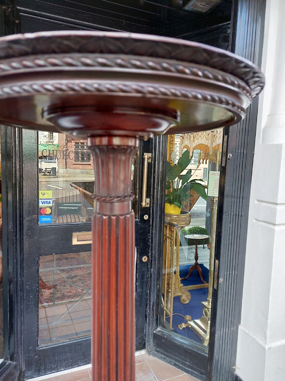 A tall mahogany Adam Revival torchere stand featuring a fluted column, carved tripod legs, and a circular top. View VII