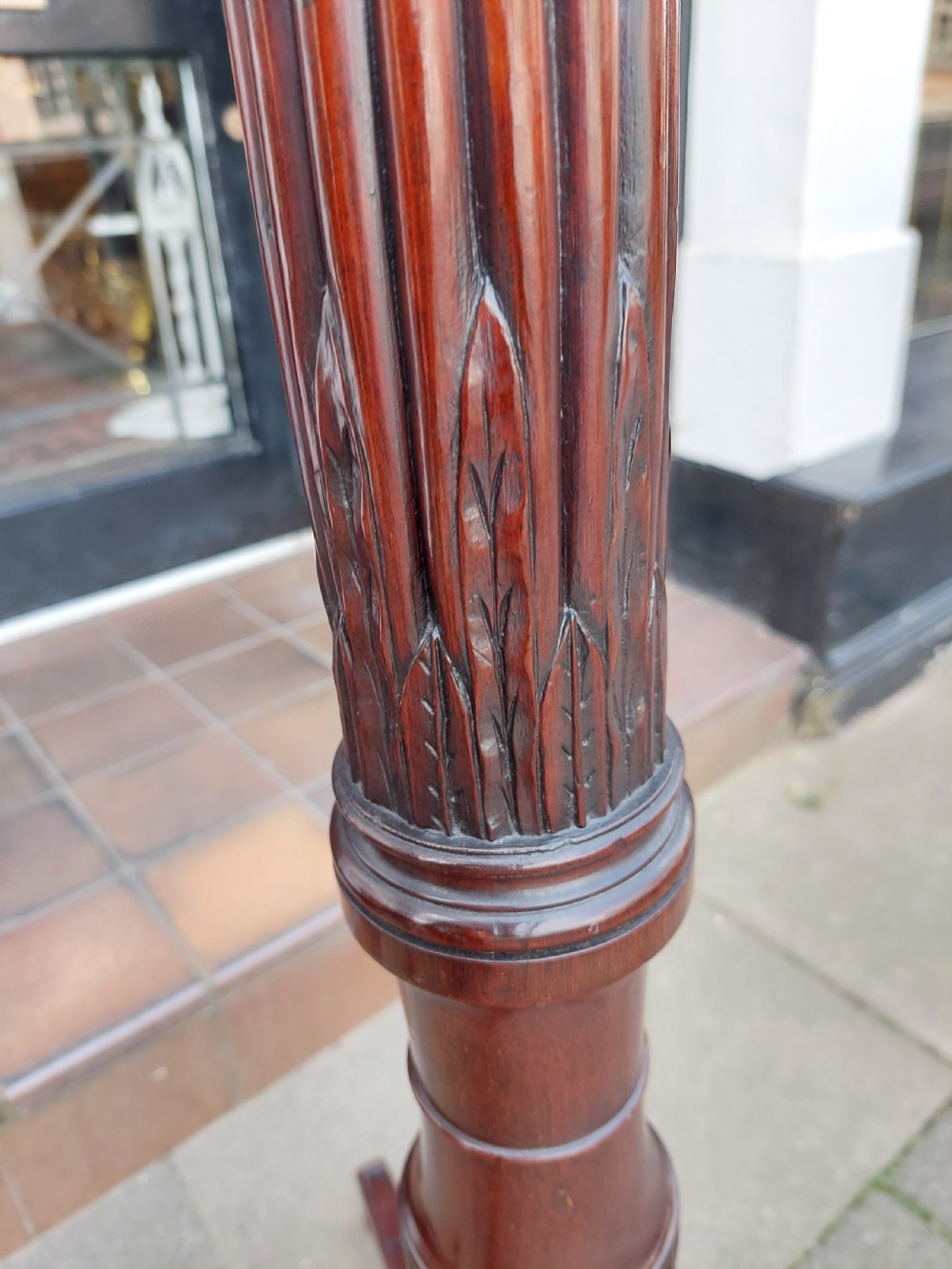 A tall mahogany Adam Revival torchere stand featuring a fluted column, carved tripod legs, and a circular top. View IX