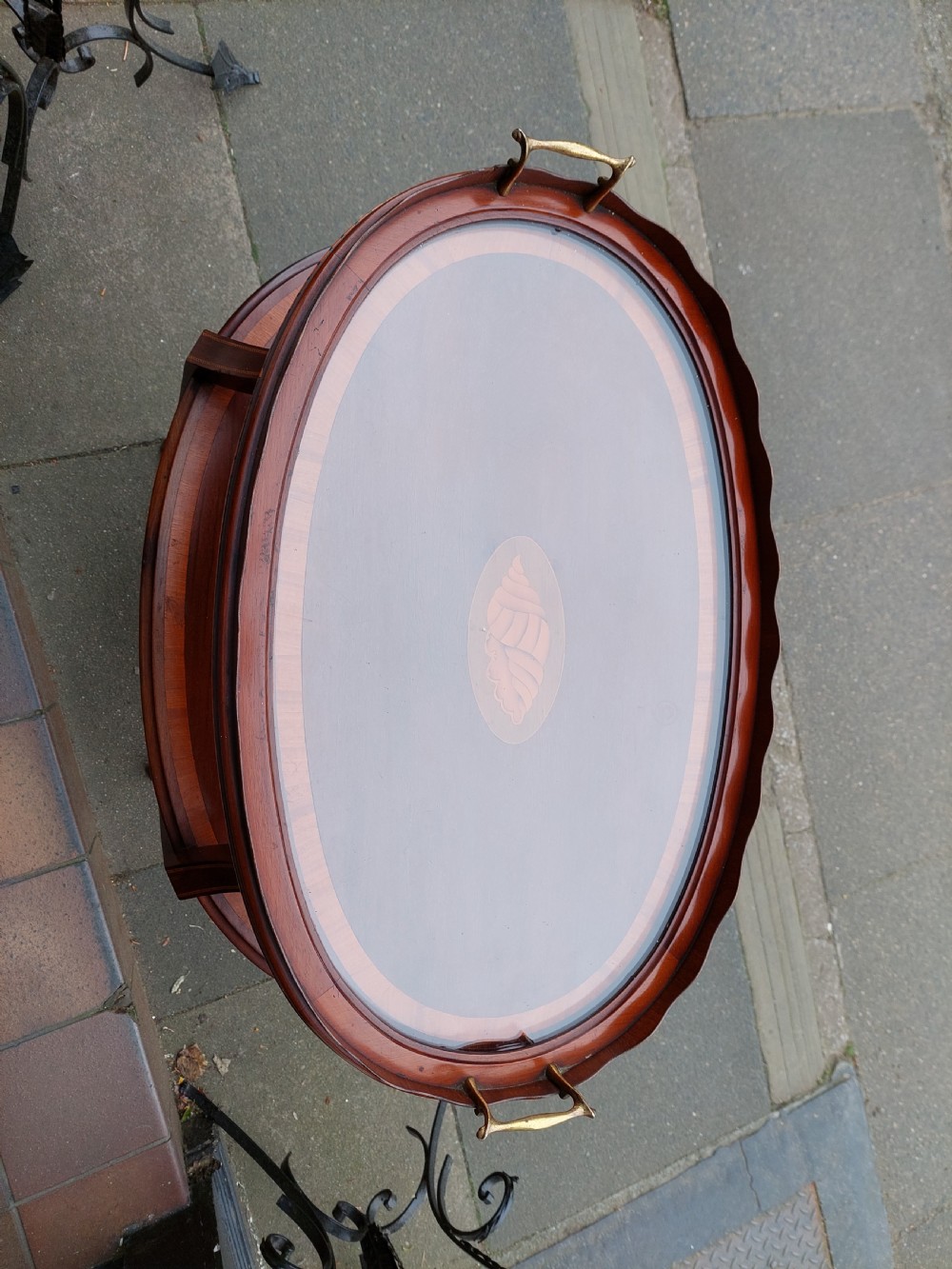 An Edwardian mahogany two-tier etagere table with satinwood oval inlays, brass side handles, and a removable glass tray top. View II