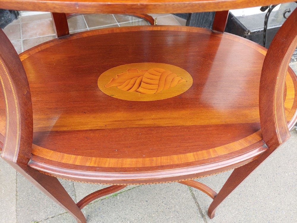 An Edwardian mahogany two-tier etagere table with satinwood oval inlays, brass side handles, and a removable glass tray top. View VII