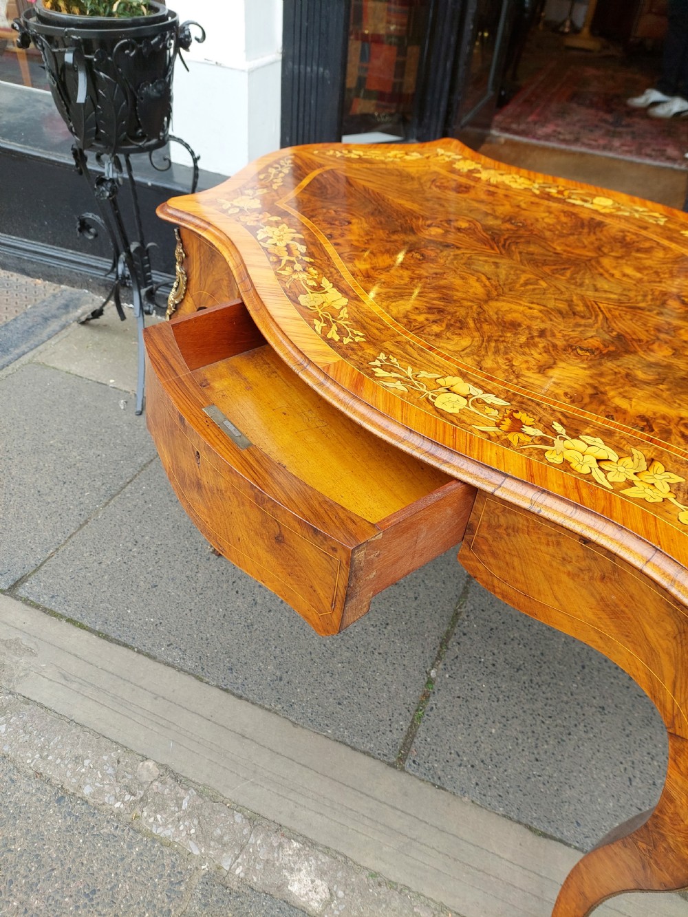 A 19th-century burr walnut bureau plat with a serpentine top featuring floral marquetry, gilt-bronze mounts, and cabriole legs. View IV