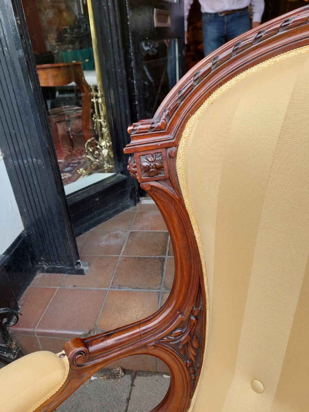 A low Victorian armchair crafted from carved dark walnut with cream striped upholstery and turned legs with brass casters. View VIII
