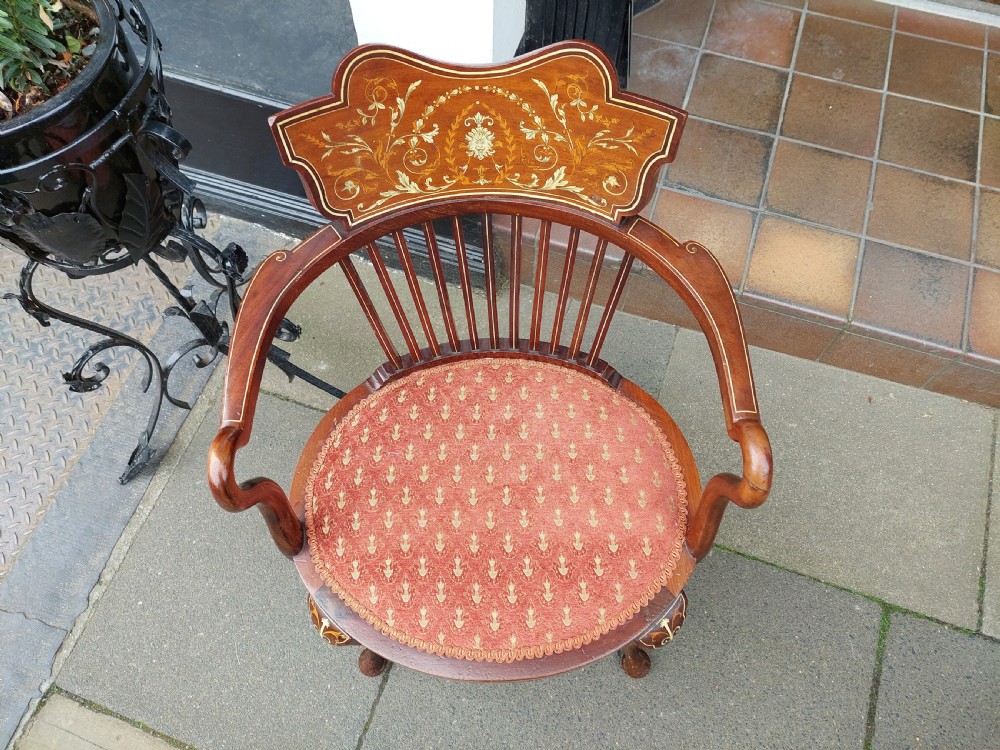 A matched pair of Edwardian mahogany tub armchairs featuring floral marquetry backsplats, thin vertical spindles, cabriole legs, and red patterned fabric seats. View III