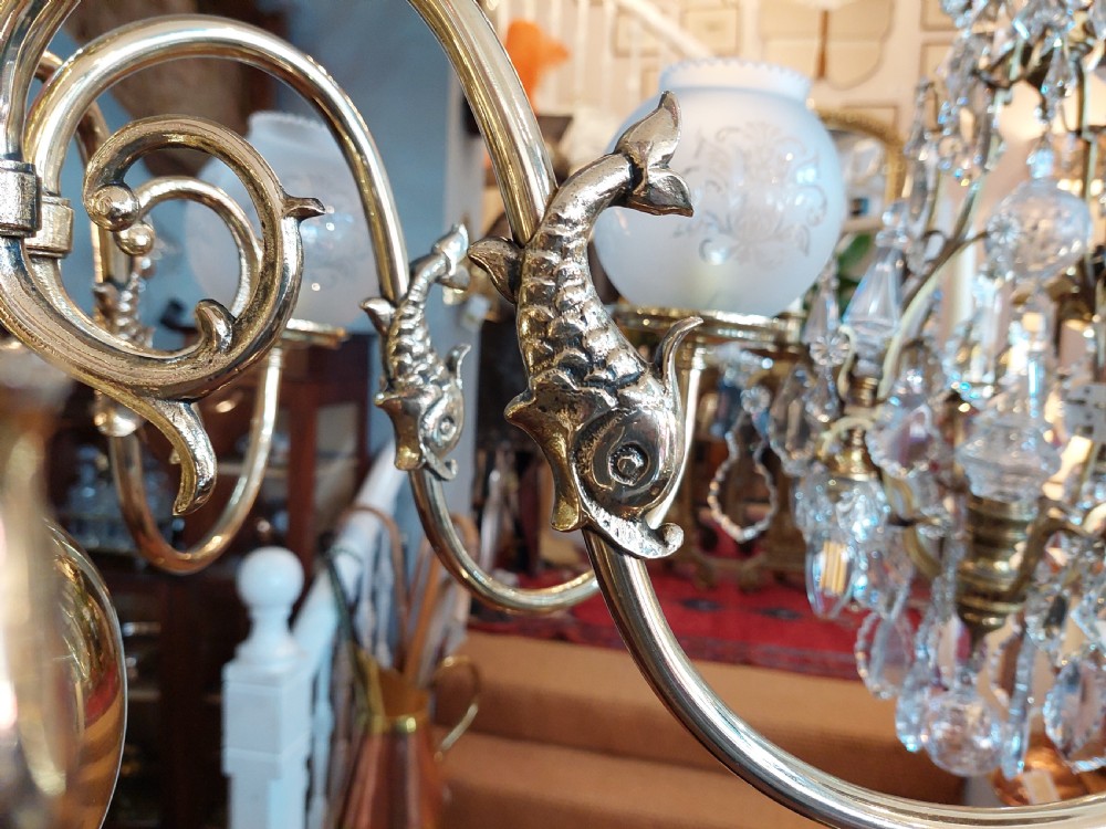 An early twentieth-century polished brass eight-arm chandelier featuring etched frosted glass shades mounted on curved arms around a central baluster stem. View III