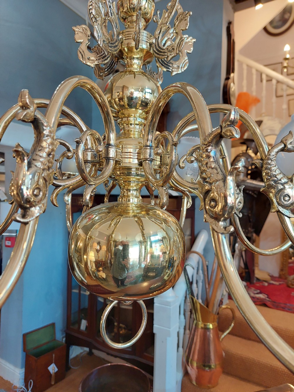 An early twentieth-century polished brass eight-arm chandelier featuring etched frosted glass shades mounted on curved arms around a central baluster stem. View IX