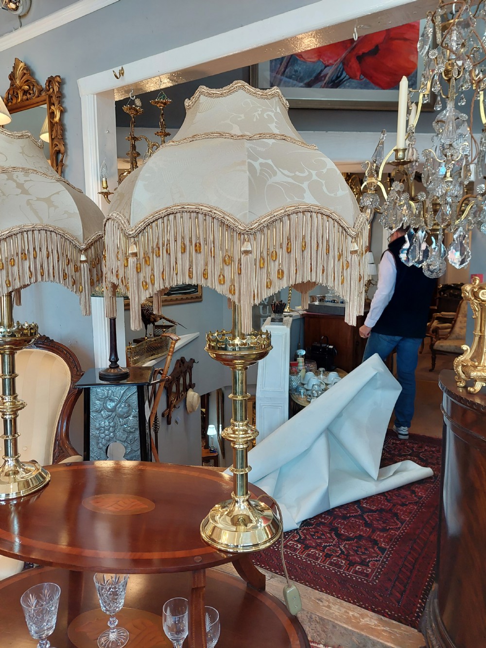 A pair of 19th-century Gothic Revival brass altar candlesticks converted into table lamps with patterned cream fabric shades featuring tassel fringe. View VIII