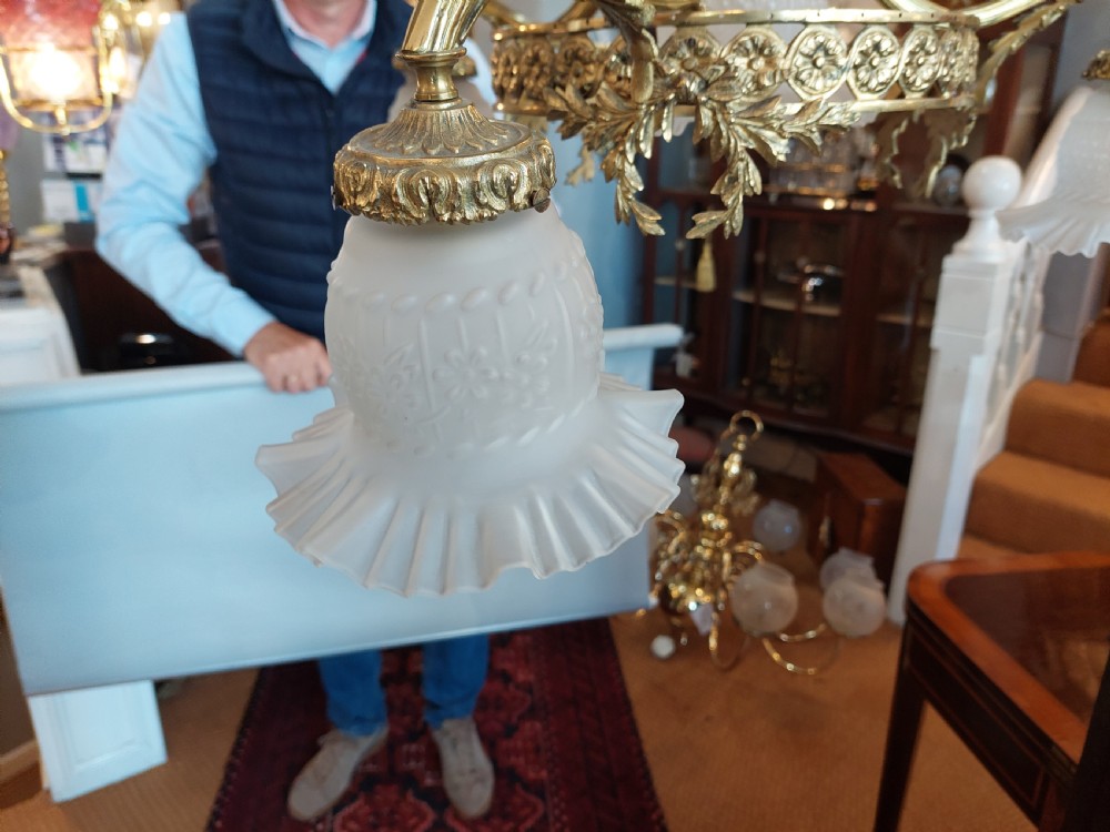 An early 20th-century French cast brass three-light chandelier featuring scrolled arms, a decorative pierced gallery ring, and frosted fluted glass shades. View VII