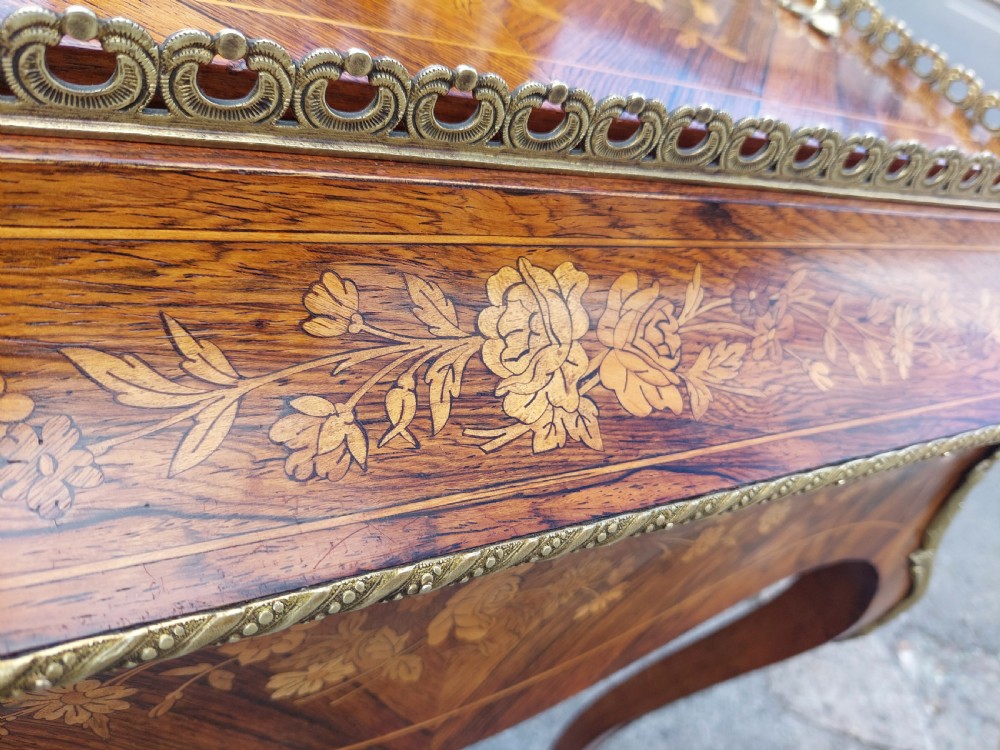 A Victorian kingwood jardiniere table featuring floral marquetry inlays, slender cabriole legs with gilt-metal mounts, and a brass gallery rim. View VI