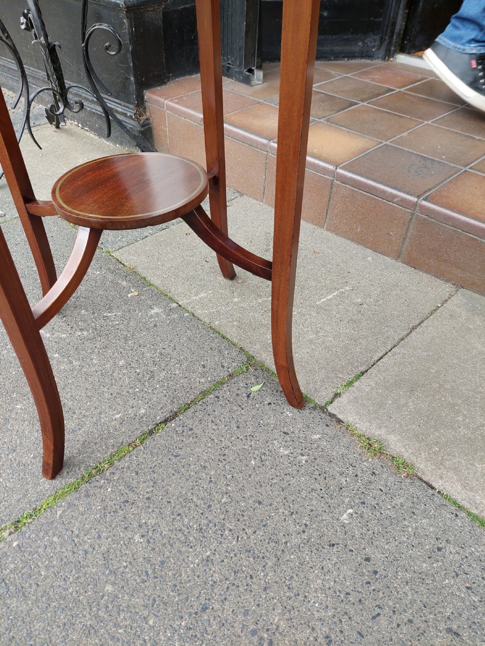 An Edwardian mahogany occasional table featuring a serpentine shaped top with inlaid floral motifs, slender splayed legs, and a central circular lower shelf. View VI