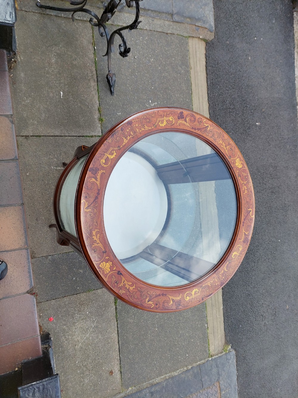 An Edwardian mahogany and marquetry oval bijouterie display table featuring curved glass sides, cabriole legs, and a glazed top. View II