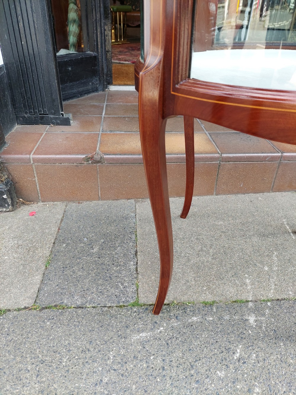 An Edwardian mahogany and marquetry oval bijouterie display table featuring curved glass sides, cabriole legs, and a glazed top. View VI