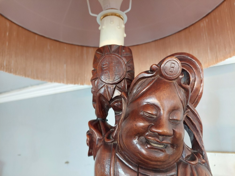 An early 20th-century Chinese carved rootwood table lamp featuring a figural base and a cylindrical shade with cream fringe and red trim. View II