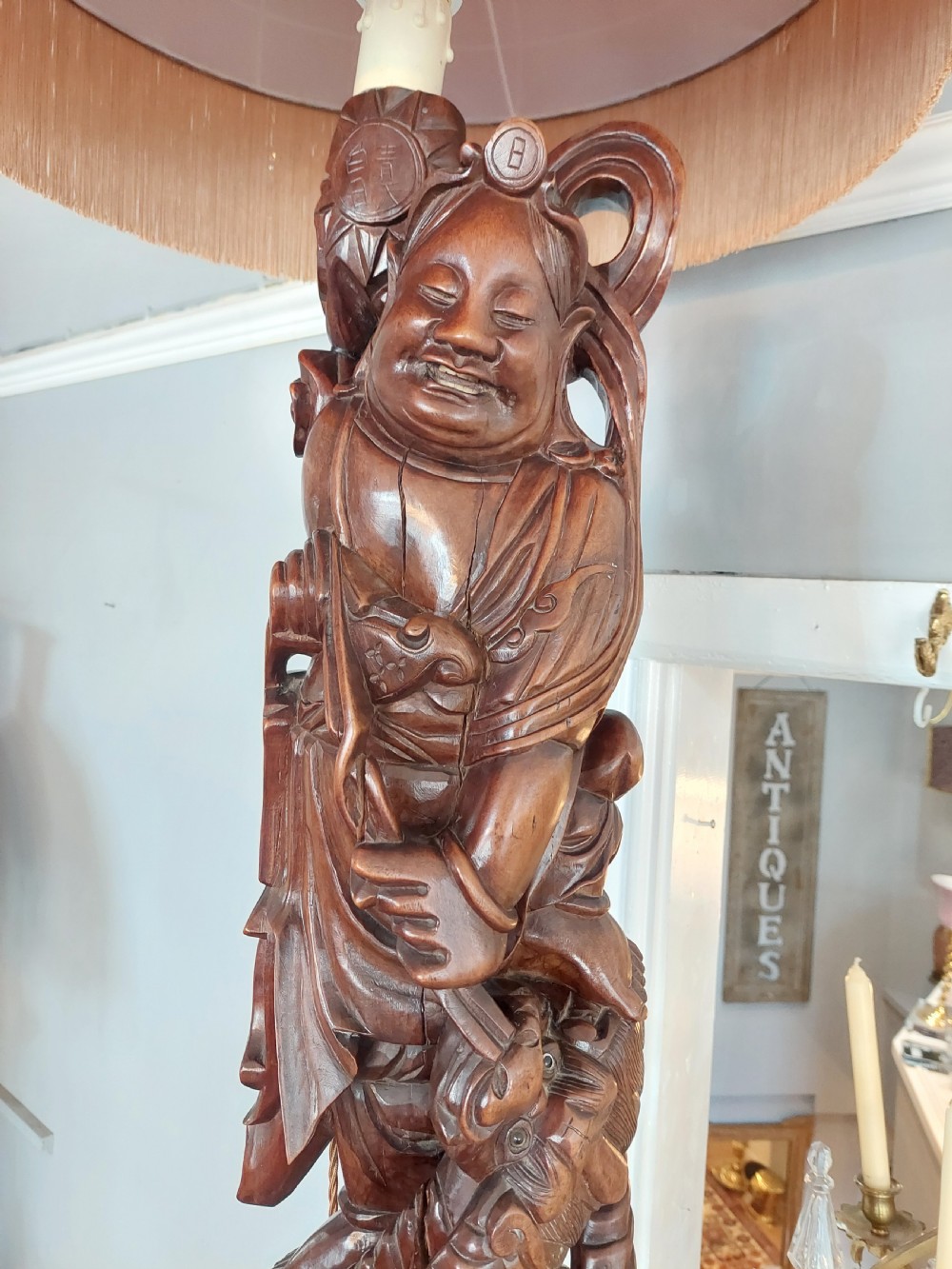 An early 20th-century Chinese carved rootwood table lamp featuring a figural base and a cylindrical shade with cream fringe and red trim. View III