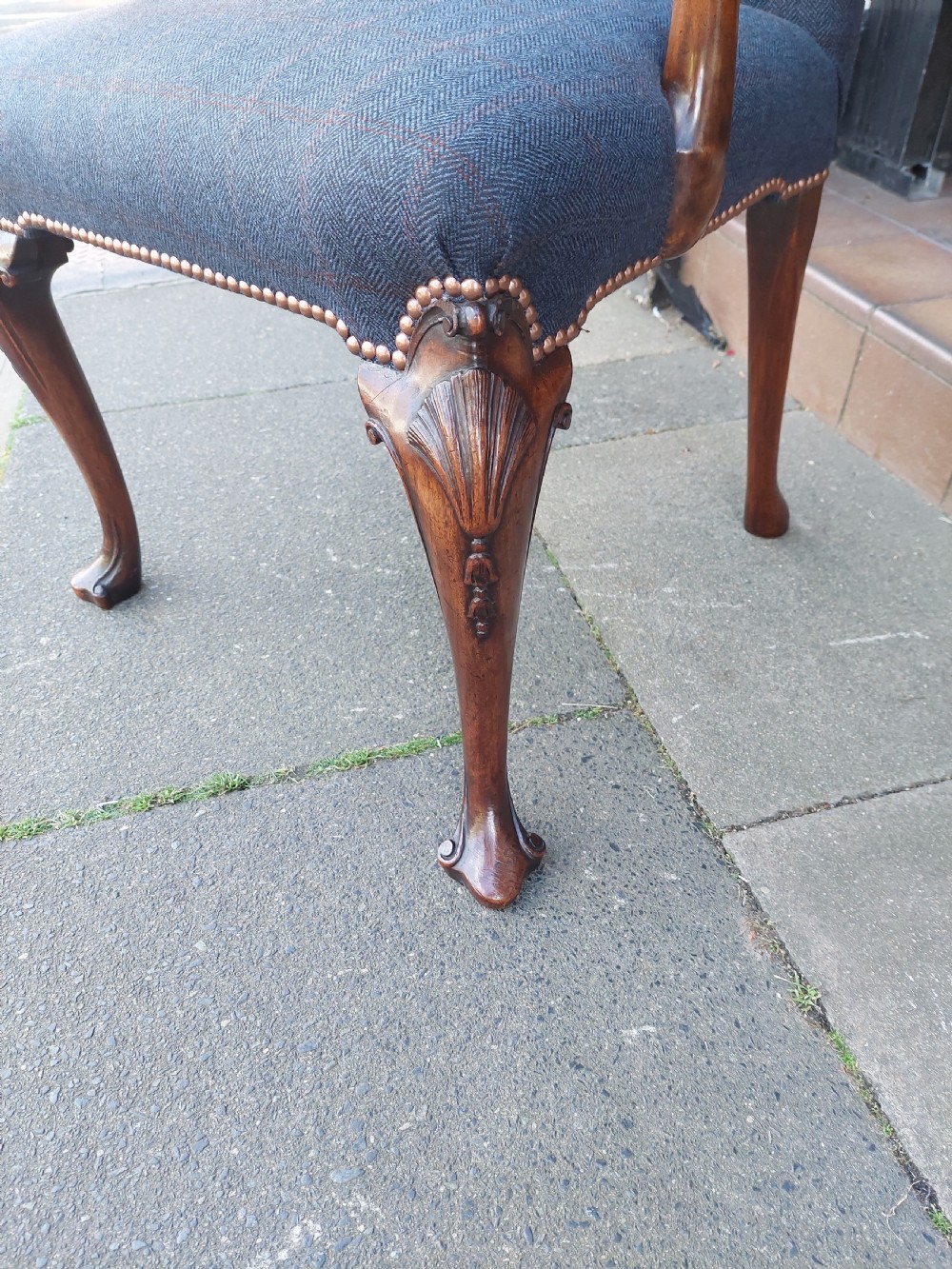 An early twentieth-century Georgian Revival high-backed armchair upholstered in blue fabric with carved walnut legs and eagle head handrests. View II