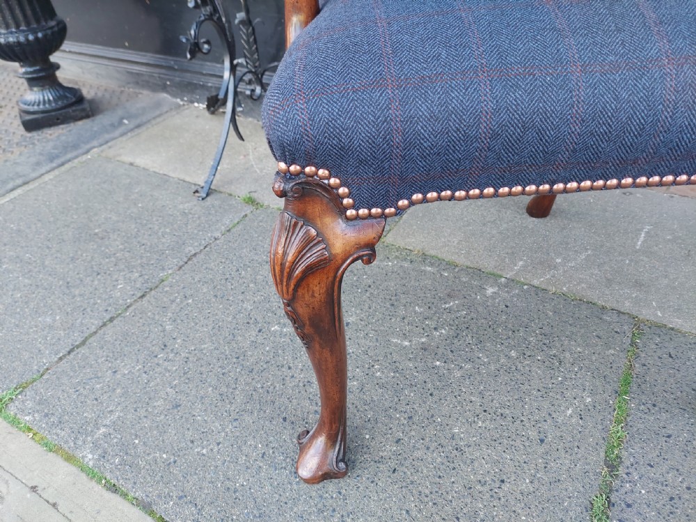 An early twentieth-century Georgian Revival high-backed armchair upholstered in blue fabric with carved walnut legs and eagle head handrests. View III