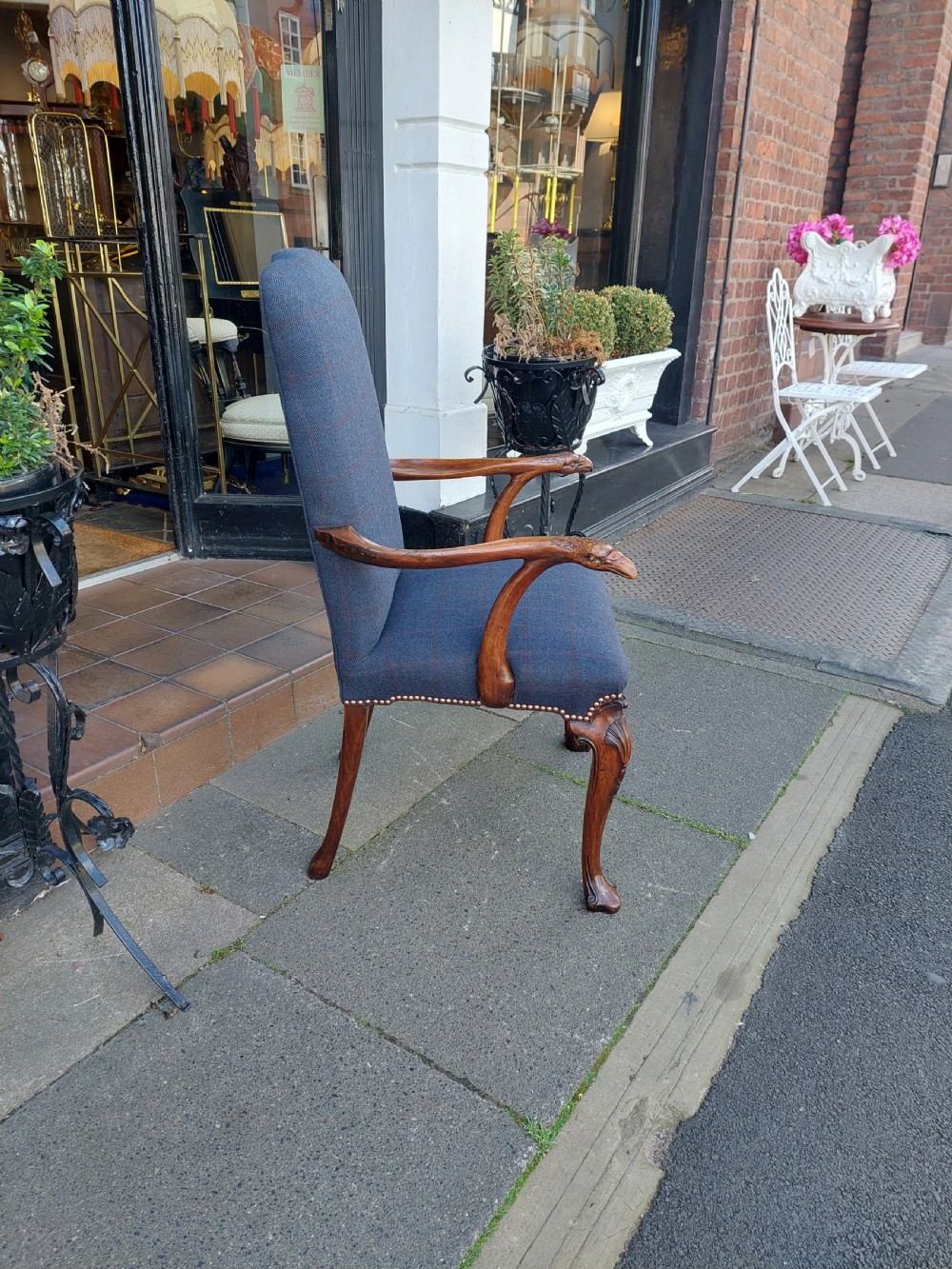 An early twentieth-century Georgian Revival high-backed armchair upholstered in blue fabric with carved walnut legs and eagle head handrests. View VI