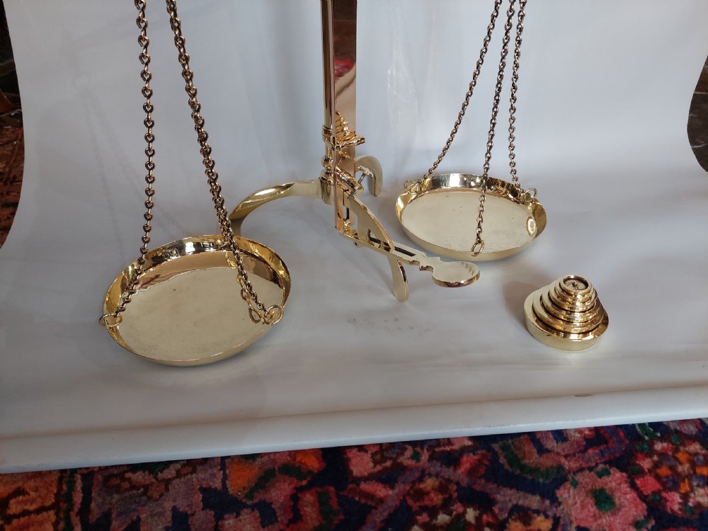 A set of Victorian polished brass beam balance scales with suspended pans and nested weights. View II