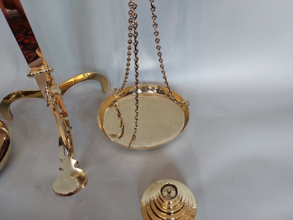 A set of Victorian polished brass beam balance scales with suspended pans and nested weights. View V
