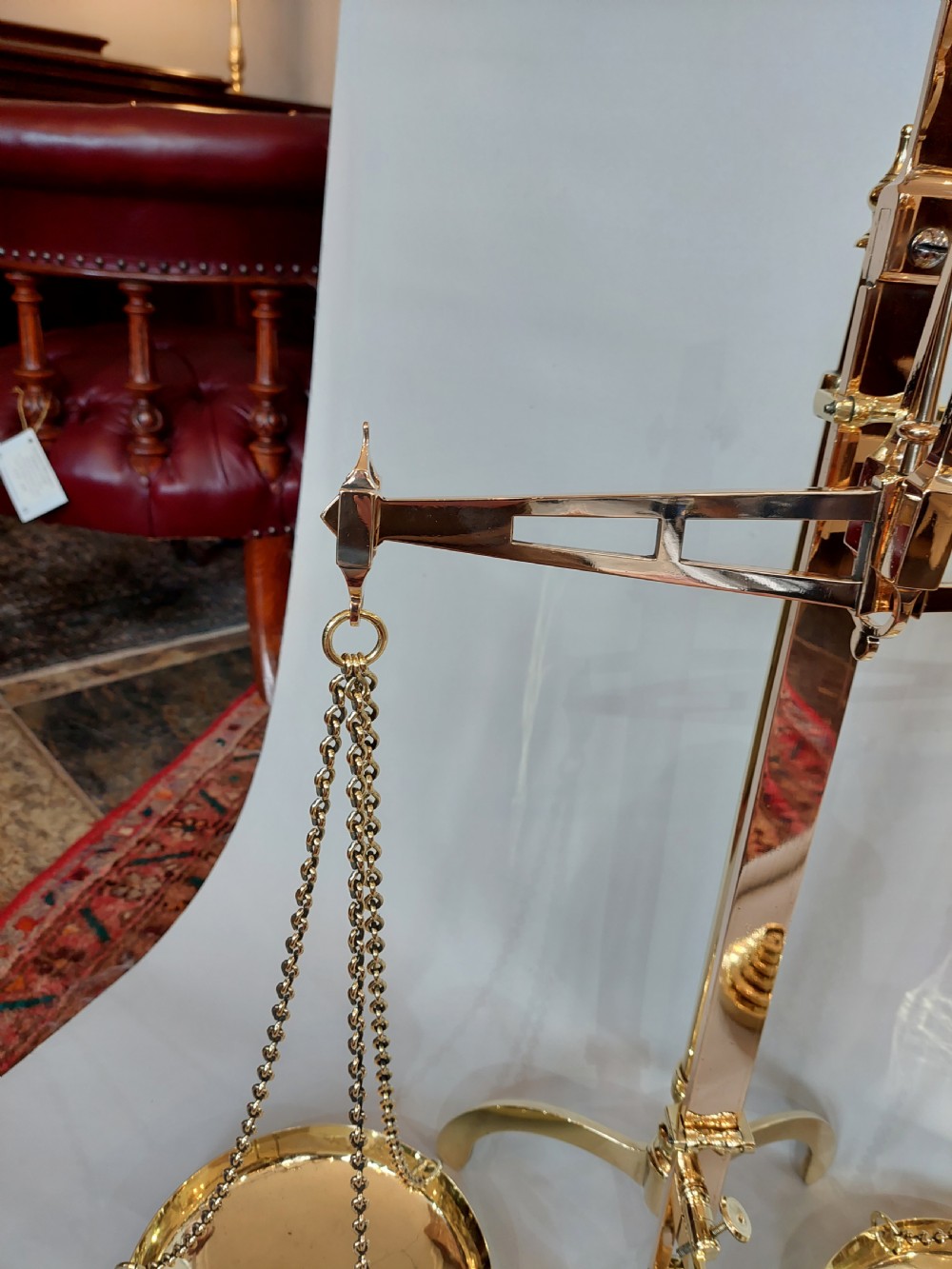A set of Victorian polished brass beam balance scales with suspended pans and nested weights. View VI