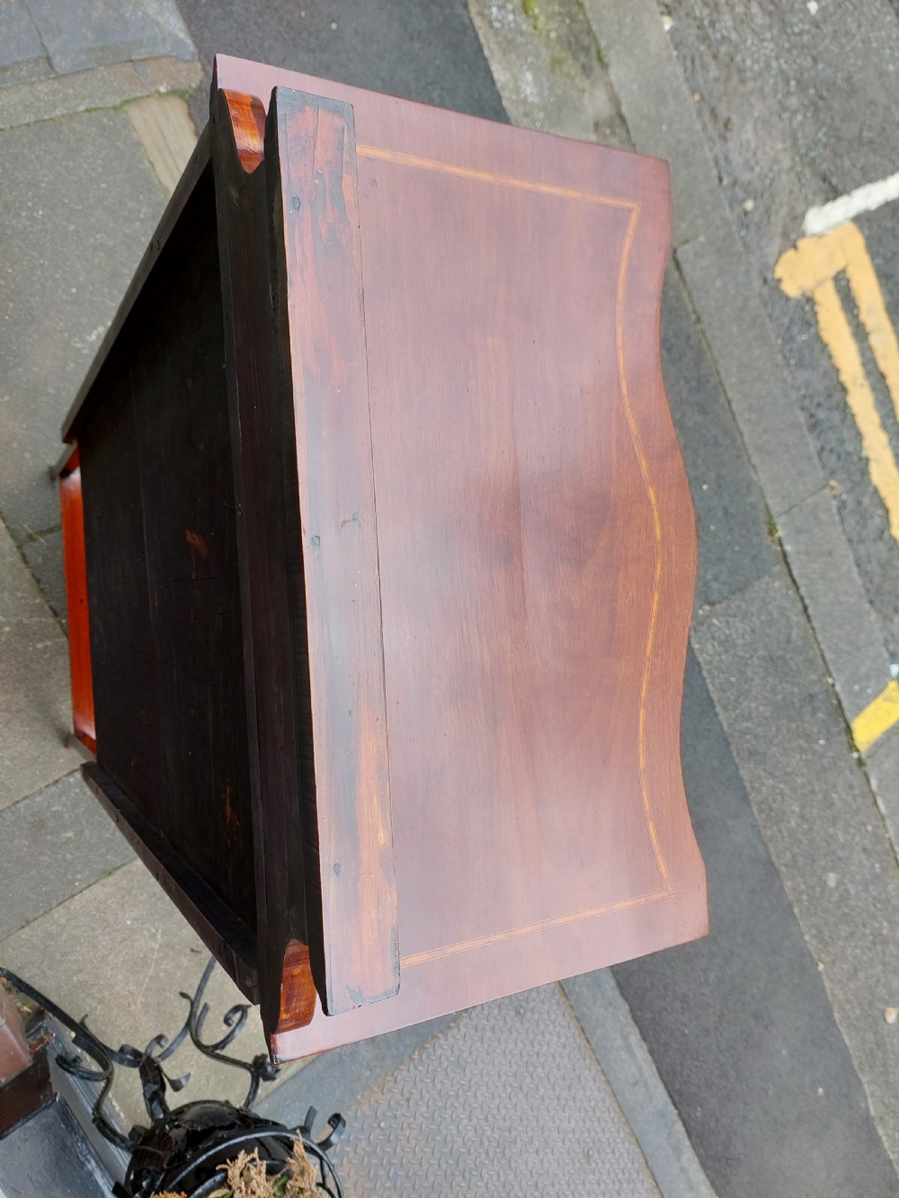 A late Victorian mahogany display cabinet featuring a serpentine glass door, satinwood stringing inlay, slender square tapered legs, and an lower undertier shelf. View VIII