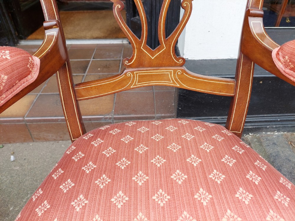 A pair of late Victorian mahogany armchairs featuring inlaid wood detail, padded armrests, and patterned pink fabric upholstery. View VII