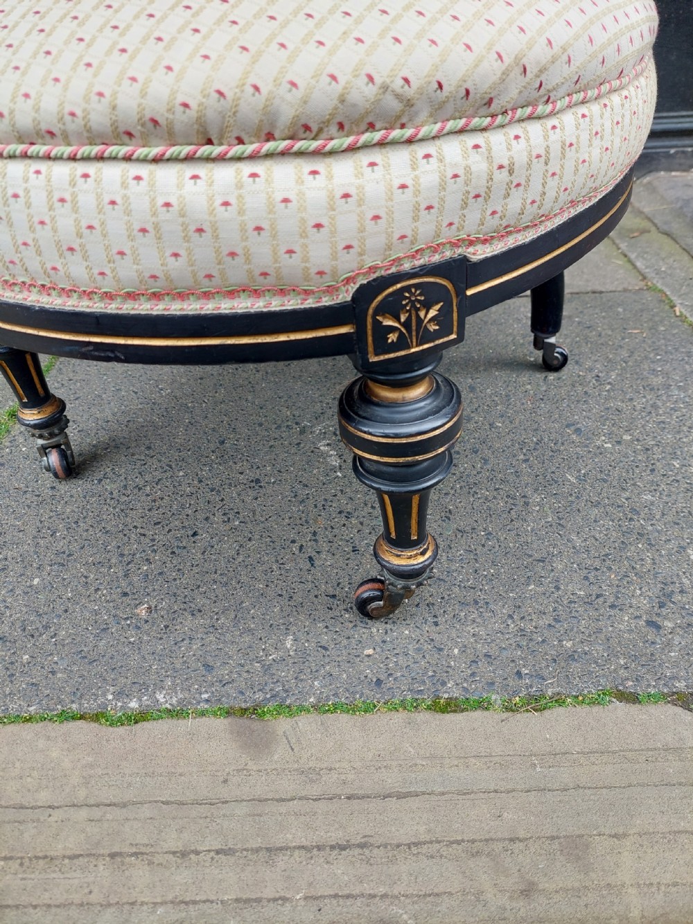 A pair of small Victorian ebonised chairs with cream patterned upholstery, turned spindles, gilt accents, and brass castors. View V