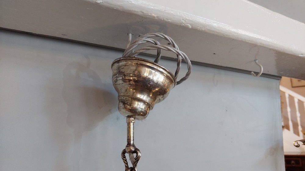 A mid-19th-century silver-plated ceiling light fitting decorated with sculpted cherub figures supporting candle sconces. View VII
