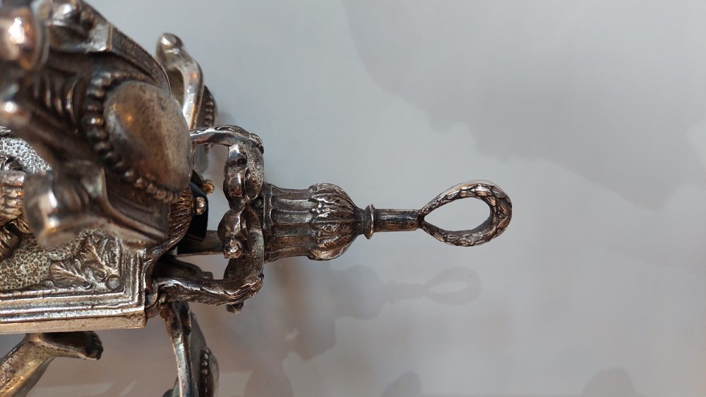 A mid-19th-century silver-plated ceiling light fitting decorated with sculpted cherub figures supporting candle sconces. View VIII