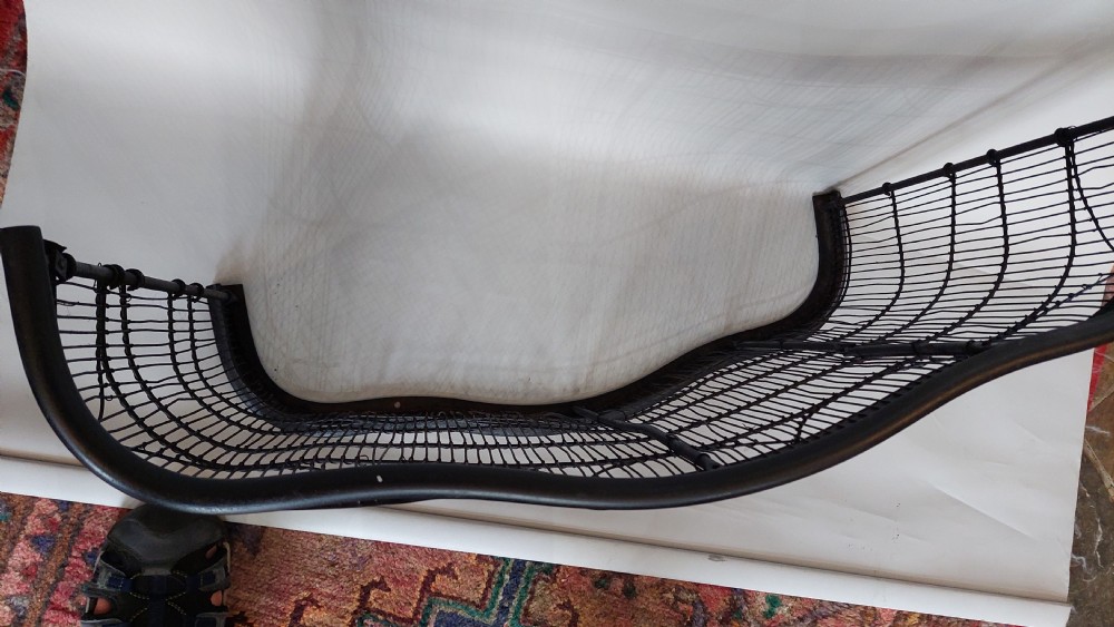 A black painted Edwardian wire mesh nursery fender with a high curved metal frame and vertical wire weaving. View IV