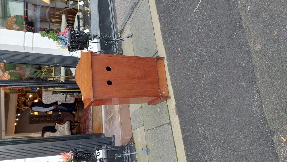 An Edwardian mahogany bedside cabinet featuring a curved front, single upper drawer, inlaid oval panel door, and shaped gallery top. View VII