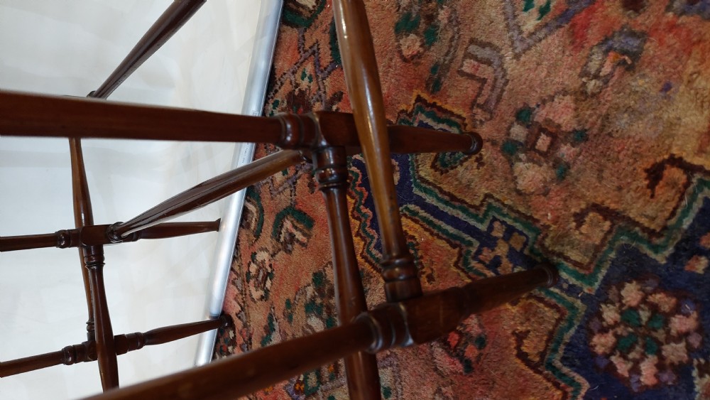 A set of three graduated Edwardian mahogany nesting tables featuring slender turned legs, cross-stretchers, and inset glass tops. View VIII