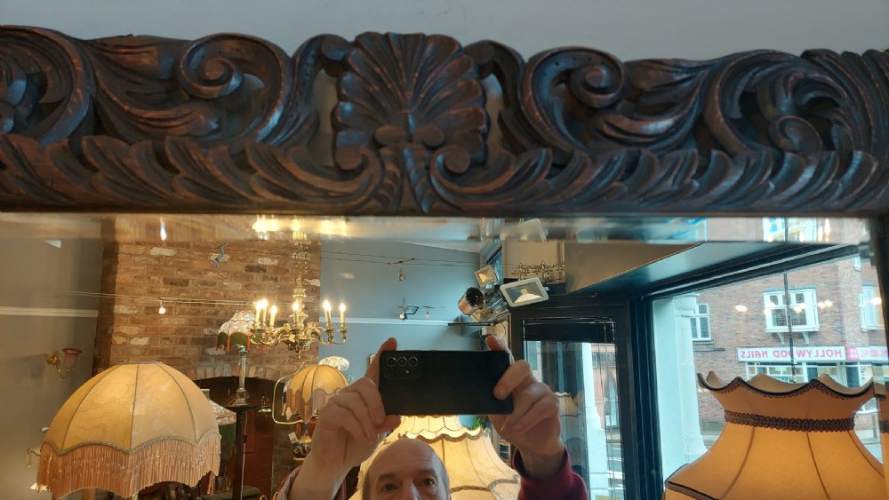 A 19th-century rectangular wall mirror featuring a heavily carved dark oak frame decorated with acanthus leaves and scroll motifs. View III