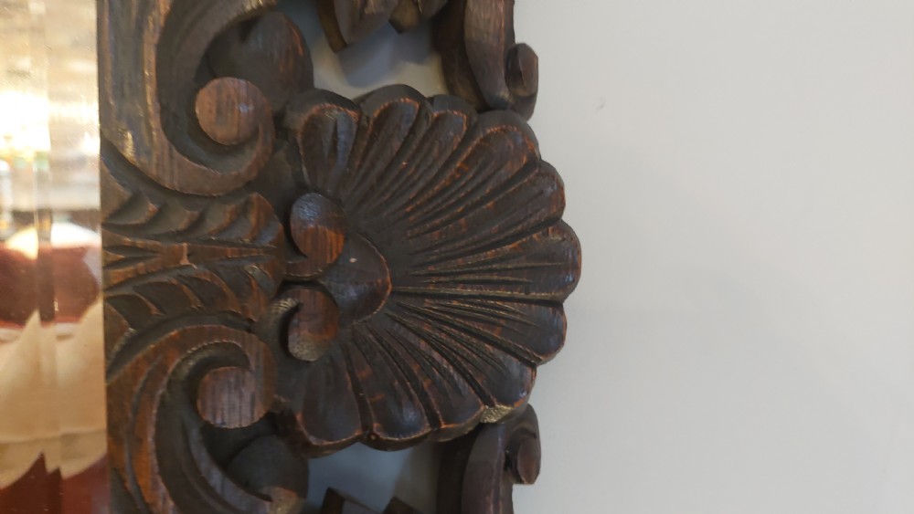 A 19th-century rectangular wall mirror featuring a heavily carved dark oak frame decorated with acanthus leaves and scroll motifs. View VI