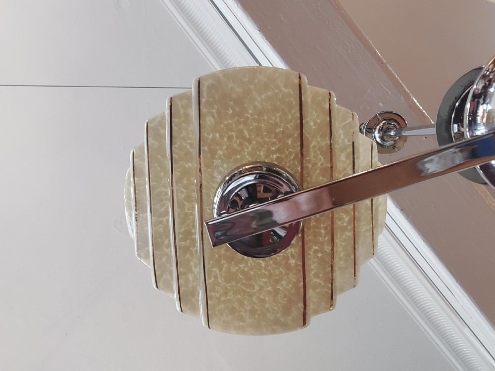A three-arm Art Deco ceiling light fixture featuring chrome metalwork, reddish bakelite collars, and three mottled cream and amber glass bowl shades. View III
