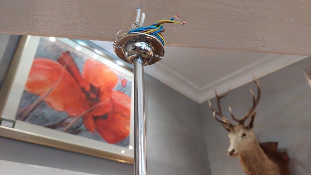 A three-arm Art Deco ceiling light fixture featuring chrome metalwork, reddish bakelite collars, and three mottled cream and amber glass bowl shades. View VII