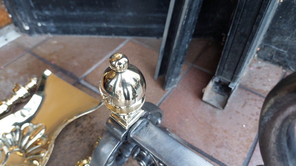 A set of Victorian hearth accessories comprising three metal fire tools resting across a pair of cast iron and brass decorated andirons. View VIII