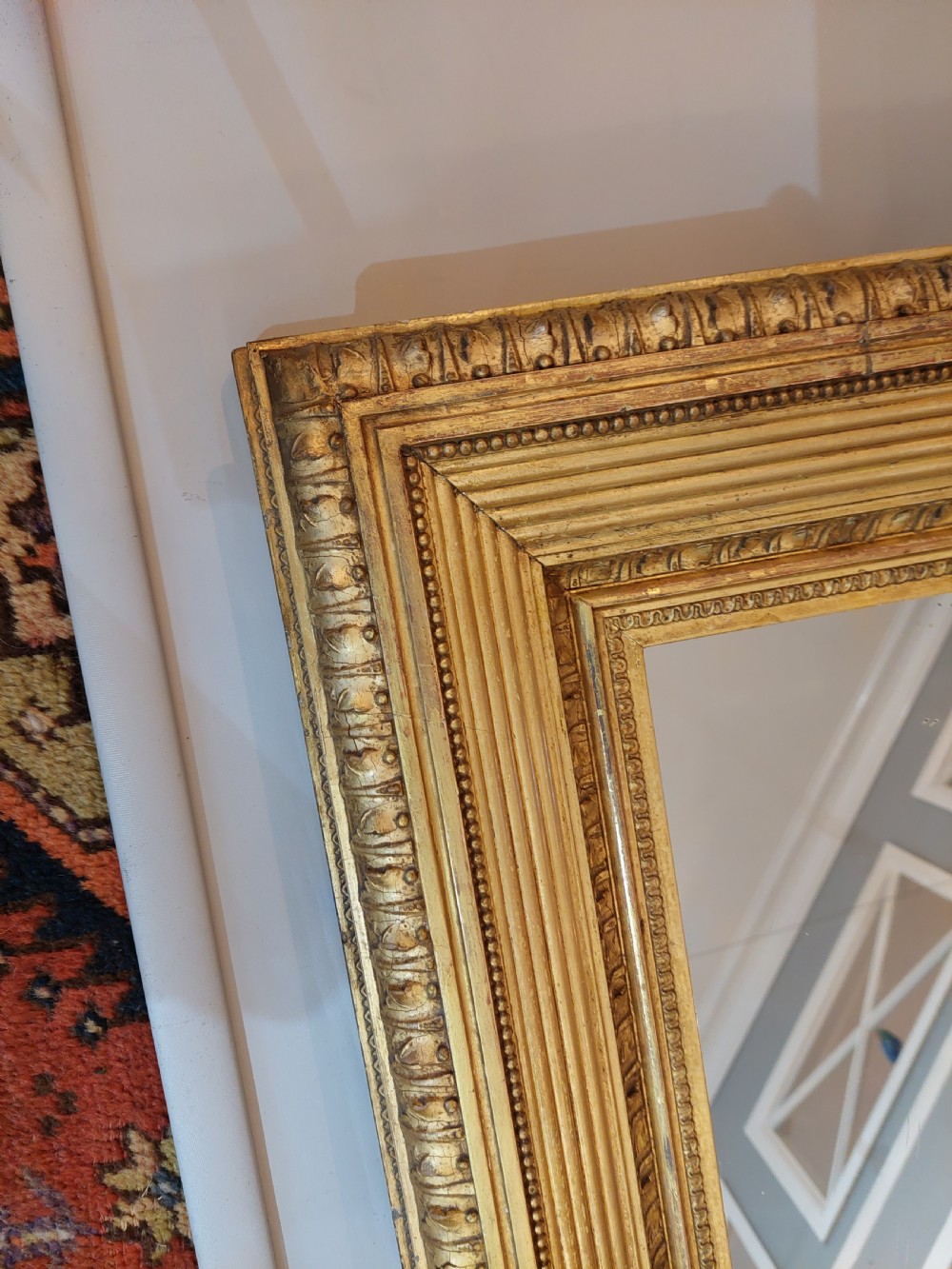 A rectangular Victorian wall mirror featuring a deep giltwood and gesso frame with ribbed moulding and beaded inner borders. View II