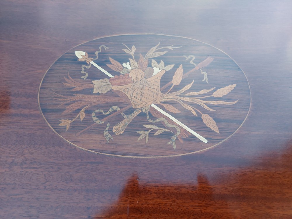 An Edwardian mahogany side table with a central oval marquetry inlay on top, fine stringing on slender tapered legs, and a shaped lower shelf. View III