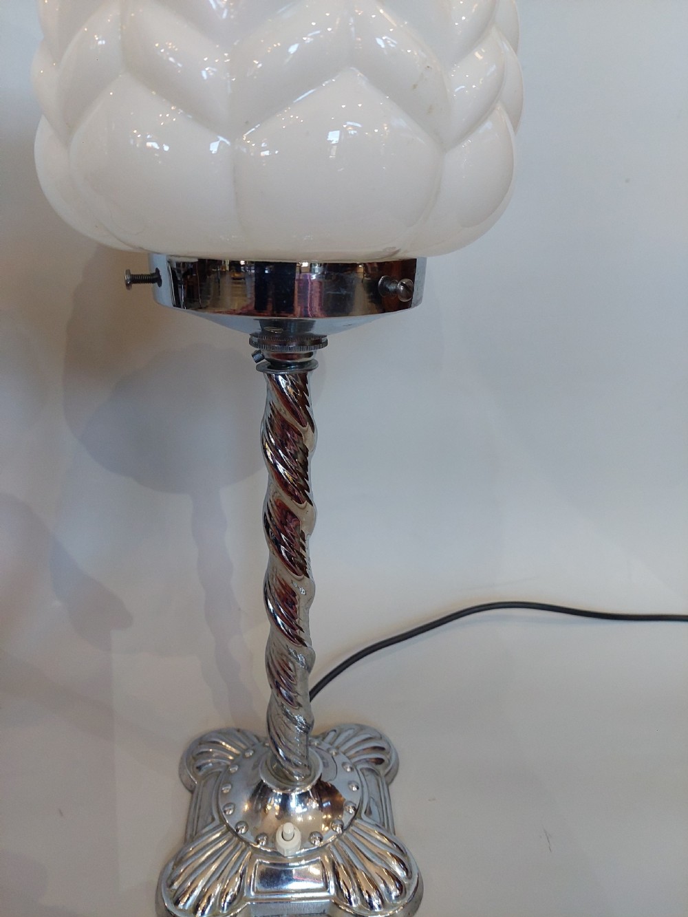 A pair of Art Deco chrome table lamps featuring twisted spiral stems, decorative square bases, and textured white glass shades. View III