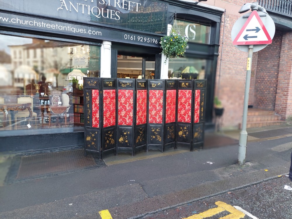 An eight-panel black lacquered folding screen with gold chinoiserie figures and floral patterned panels. View II