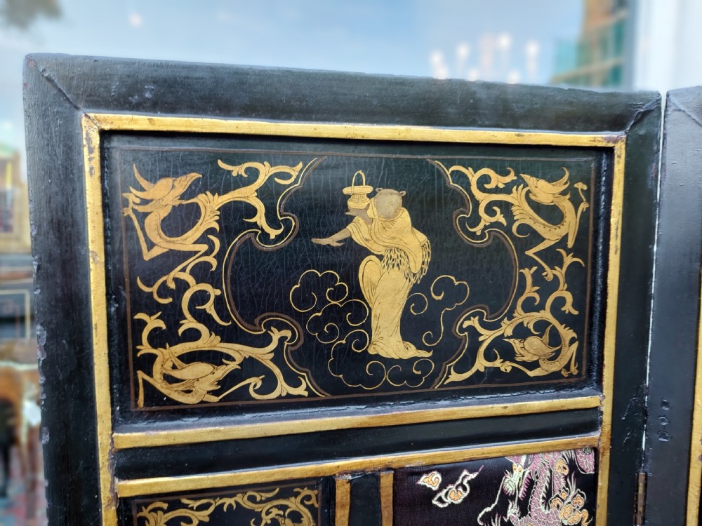 An eight-panel black lacquered folding screen with gold chinoiserie figures and floral patterned panels. View V
