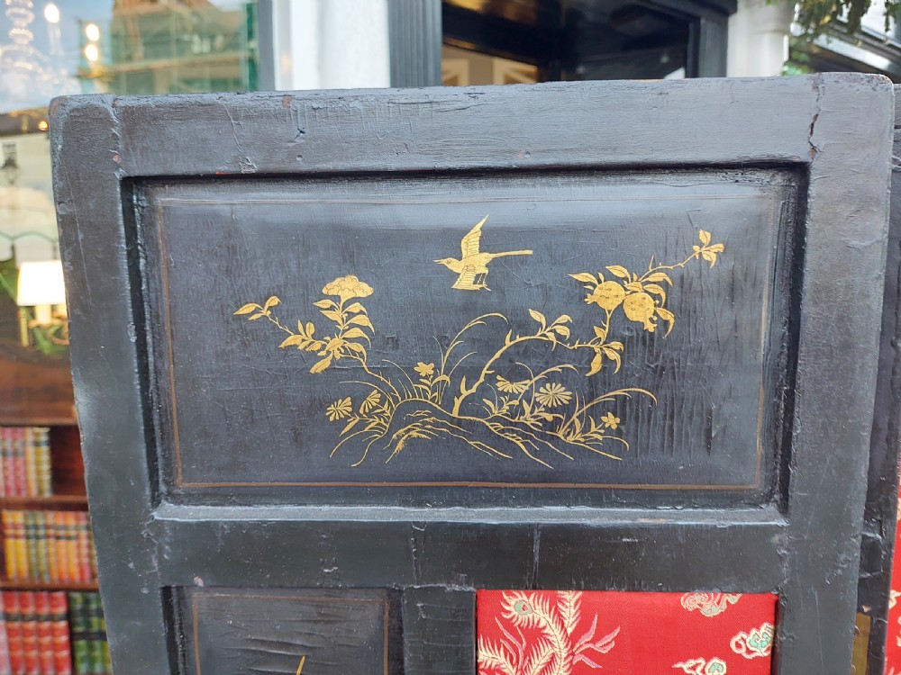 An eight-panel black lacquered folding screen with gold chinoiserie figures and floral patterned panels. View VIII