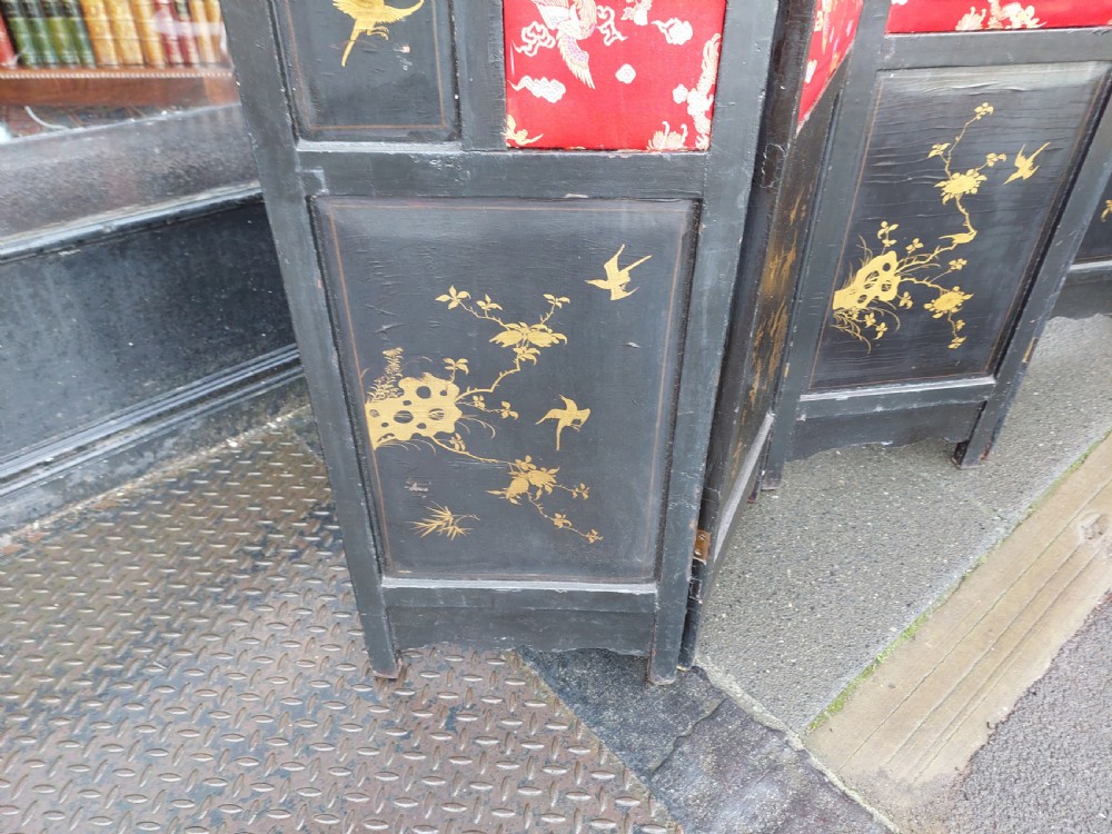 An eight-panel black lacquered folding screen with gold chinoiserie figures and floral patterned panels. View X